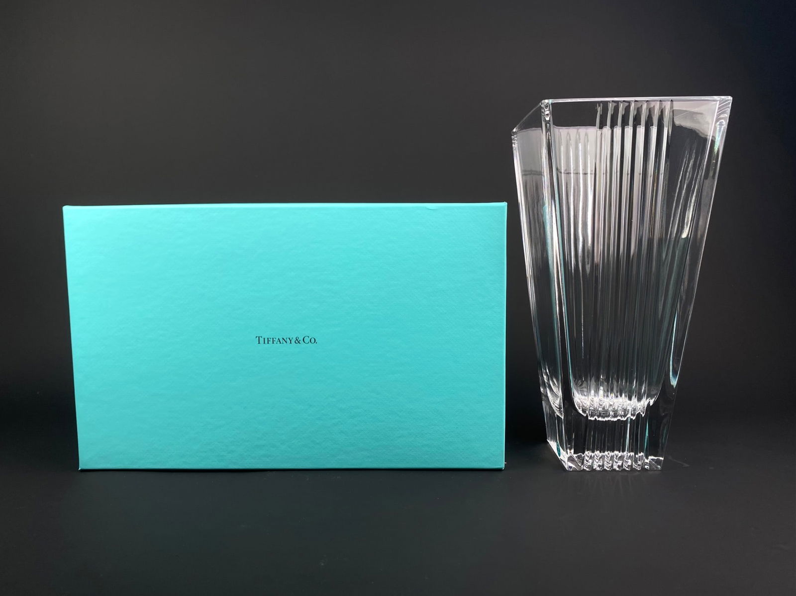 Tiffany & Co. Square Fluted Crystal Vase, Made in Italy, with Box: Tiffany & Co. crystal vase of tall square form, featuring vertical fluted panels and sharply defined edges with a thick, stepped base. The vase retains the original Tiffany & Co. “Made in Italy&rdqu