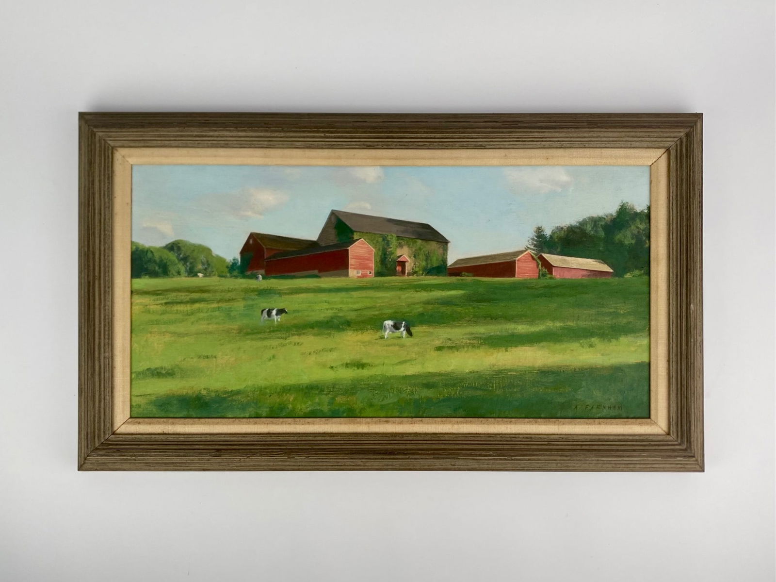 ‘Early Morning Grazing’ Oil Painting by Alexander Farnham: Oil painting titled ‘Early Morning Grazing’ depicts a pastoral farm scene with grazing cows in a green field before a grouping of red barns under a soft blue sky. The work is signed in the lower