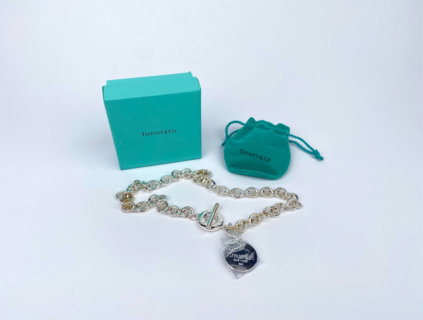 Tiffany & Co. Sterling Silver Return to Tiffany Toggle Necklace with Box & Pouch: Tiffany & Co. sterling silver Return to Tiffany toggle necklace featuring a circular engraved tag marked ‘Please Return to Tiffany & Co. New York 925.’ Includes the signature Tiffany & Co. blue bo