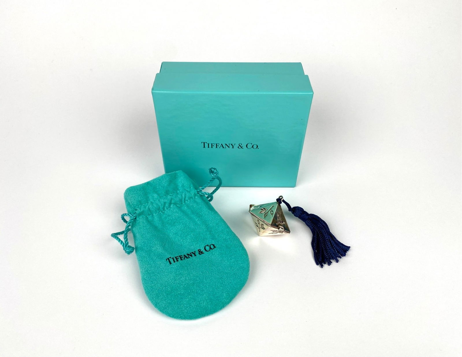 Tiffany & Co. Sterling Silver Hexagon Bamboo Pill Box with Box & Pouch: Tiffany & Co. sterling silver pill box featuring engraved floral motifs and a blue tassel. Marked ‘Tiffany & Co., 925, Spain’ on the edge. This hexagonal, hinged design opens to reveal a gold-tone