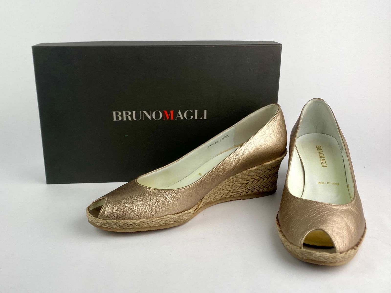 Bruno Magli Metallic Leather Peep-Toe Wedge Heels, Size 9.5 AA: Pair of Bruno Magli metallic leather peep-toe wedge heels in a champagne tone. Crafted in Italy, the shoes feature textured metallic leather uppers, woven espadrille-style wedge heels, and rubber outs