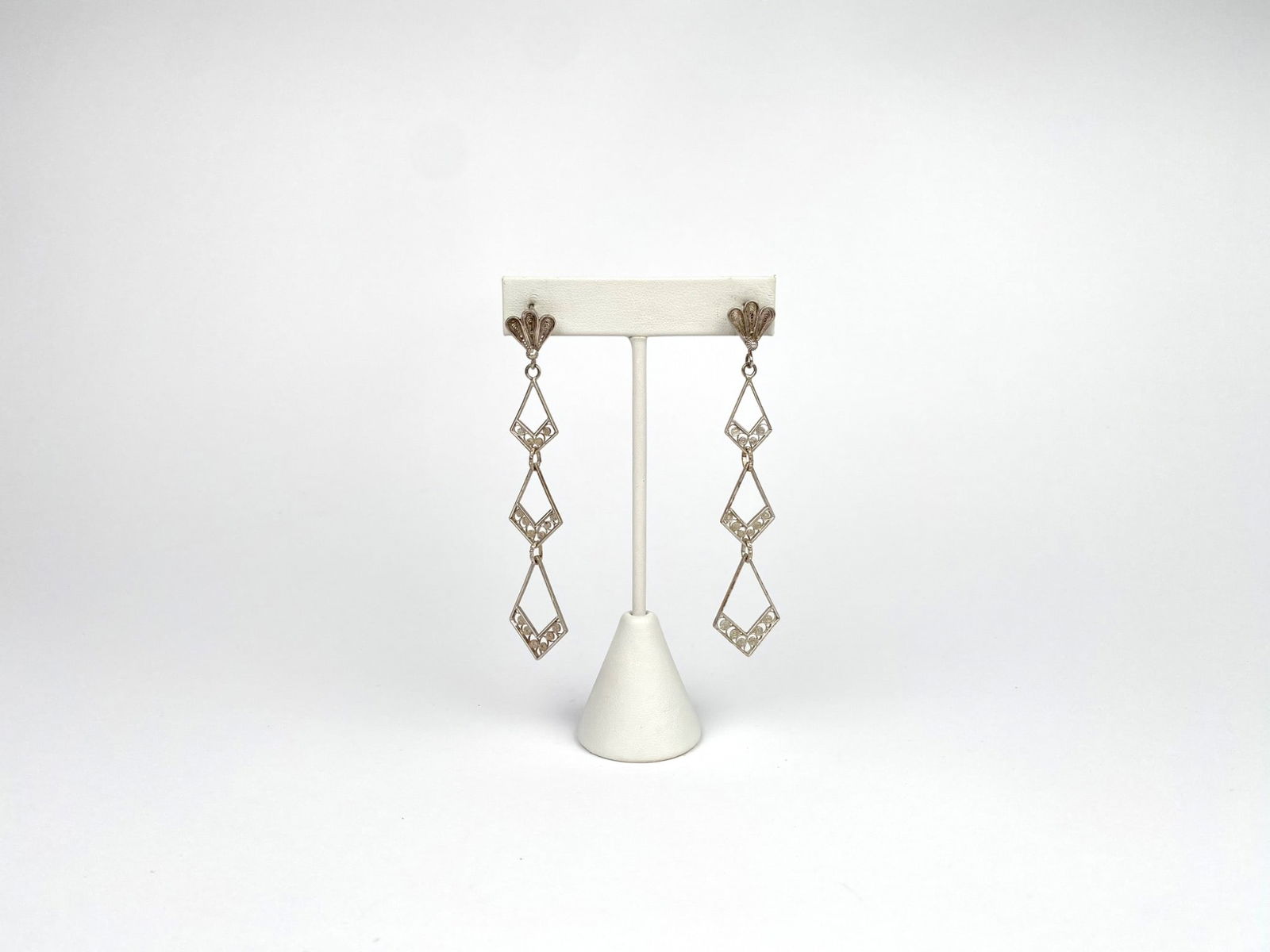 Vintage Filigree Silver-Tone Dangle Earrings: Filigree dangle earrings featuring an intricate openwork design with three diamond-shaped segments. The earrings are are silver-tone and have some light wear consistent with age and use. | Please see