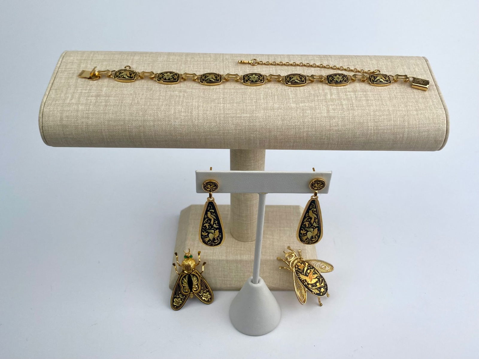 Vintage Damascene-Style Gold-Tone Jewelry Set: Vintage damascene-style jewelry set includes a gold-tone link bracelet, a pair of drop earrings, and two figural insect brooches. The bracelet and earrings feature black enamel-style panels with gold-
