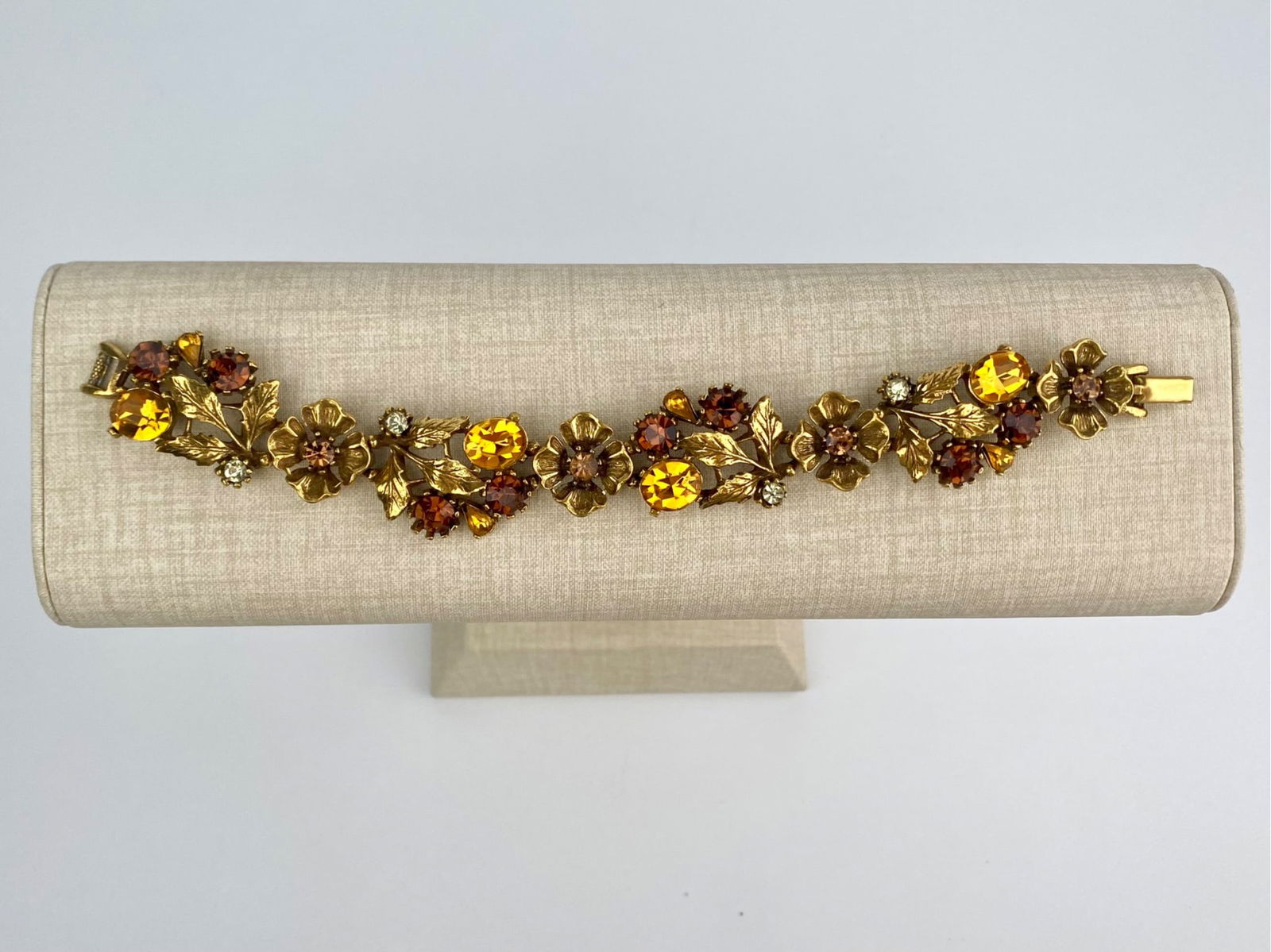 Vintage Gold Tone Floral Bracelet with Amber-Toned Rhinestones: Vintage bracelet features an articulated floral link design in gold tone metal, accented with faceted rhinestones in amber and cognac tones, along with smaller clear stones. The bracelet secures with