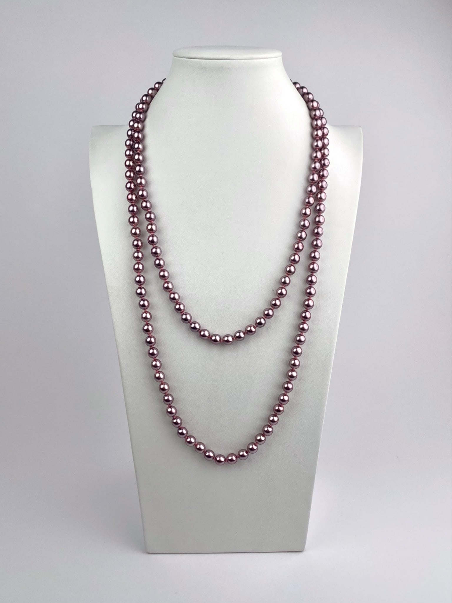 Kenneth Jay Lane (KJL) Long Mauve Faux Pearl Necklace: Vintage single strand necklace by Kenneth Jay Lane featuring mauve-tone faux pearls with individually knotted construction. The necklace is finished with a gold-tone clasp marked “KJL.” Neckla