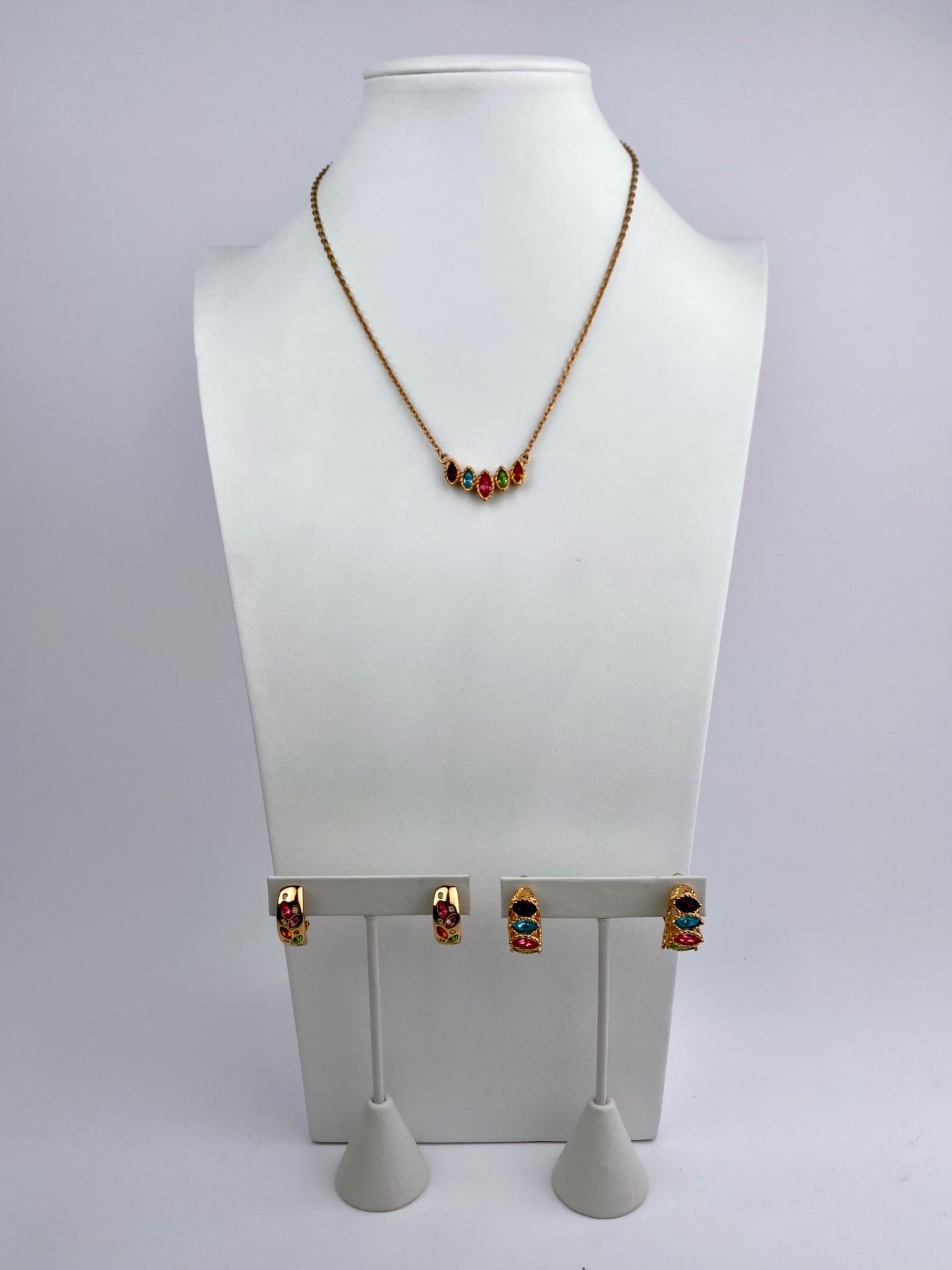 Gold-Tone Multi-Color Rhinestone Necklace & Clip-on Earrings Set: Coordinated gold-tone necklace and pair of clip-on earrings set featuring marquise-cut rhinestones in a multi-color palette including pink, green, blue, amber, and purple hues. The necklace displays a