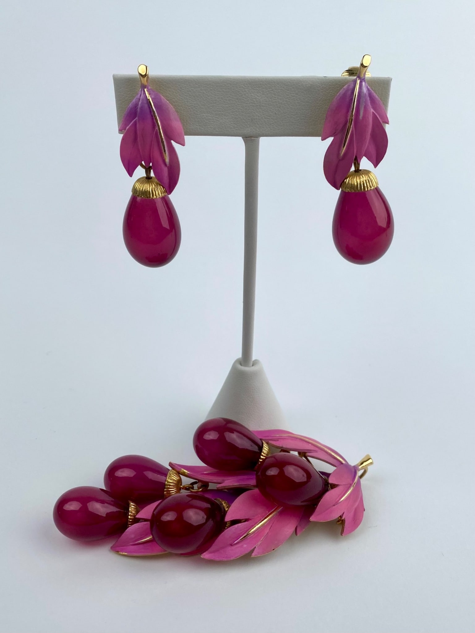 Park Lane Pink Enamel & Teardrop Dangle Brooch and Clip-on Earring Set: Signed Park Lane brooch and matching clip-on earring set featuring layered pink enamel leaves accented by gold-tone detailing and suspended teardrop-shaped resin drops in coordinating magenta tones. T