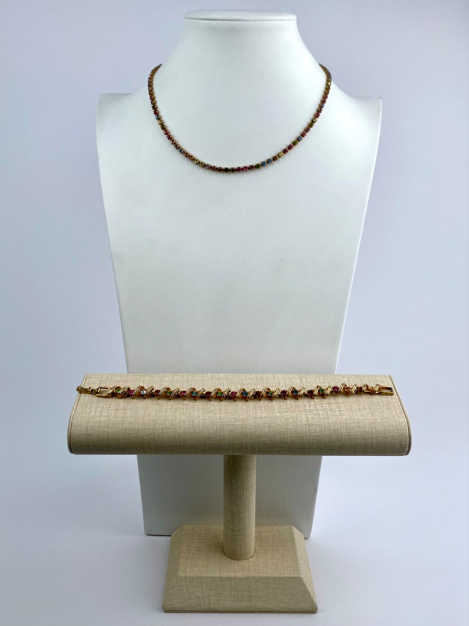 Vintage Yechang Multicolor Rhinestone Necklace & Bracelet Set: Coordinating necklace and bracelet set by Yechang featuring multicolor rhinestones in pink, blue, green, amber, and clear tones set within gold-tone metal. The necklace is designed in a classic tennis