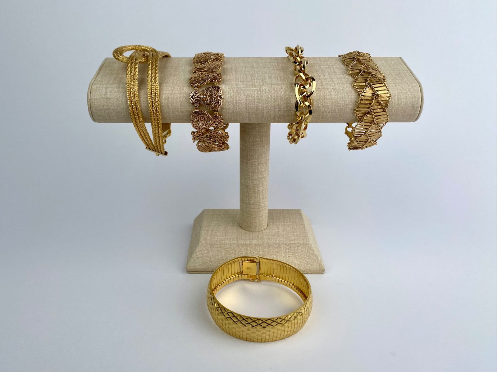 Set of Five Gold Tone Sterling Silver Bracelets: Group of gold=tone bracelets including multiple chain and link styles. The set features a variety of constructions such as multi-strand rope designs, curb and oval link chains, a wide textured panel b