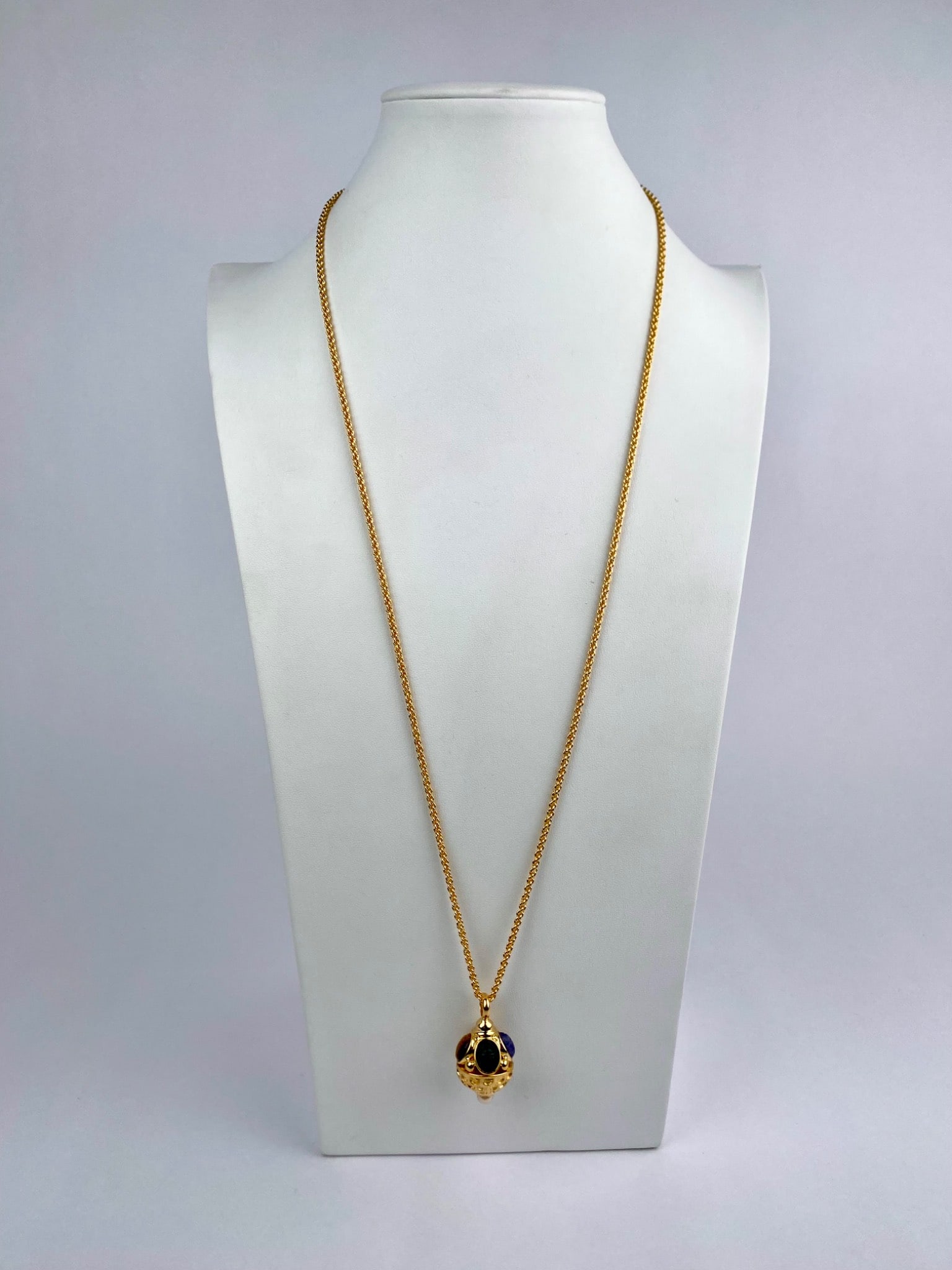 Gold-Tone Scarab Carved Cabochon Pendant Necklace with Pearl Drop: Gold-tone necklace featuring a sculptural pendant set with multiple oval cabochons carved in a scarab motif, rendered in assorted colors including green, blue, red, and brown tones. The domed pendant