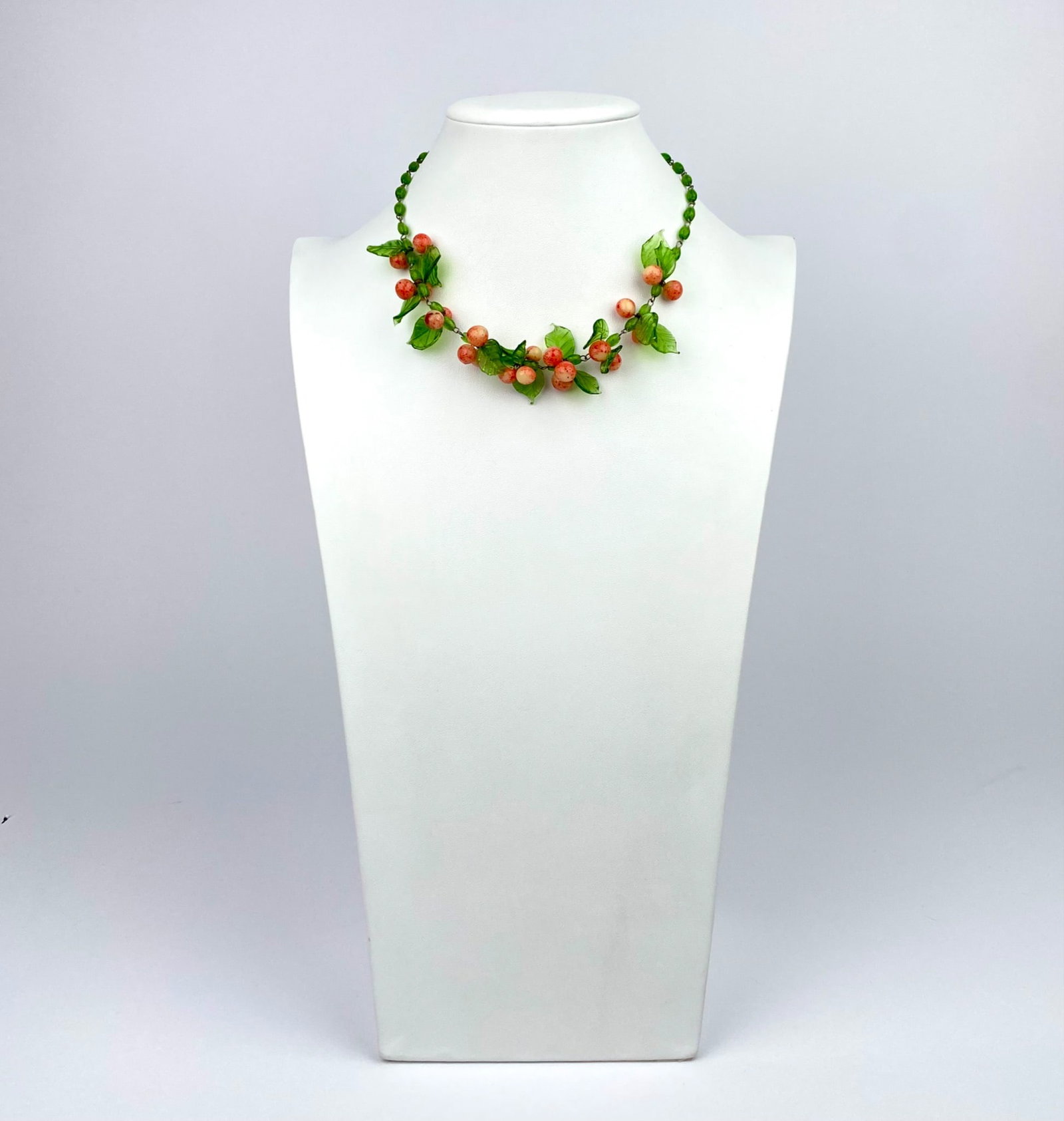 Vintage Venetian Murano Glass Fruit Necklace: Vintage Venetian Murano glass fruit necklace featuring a delicate arrangement of green and orange glass beads forming a leaf and fruit motif. The necklace is joined with a clasp closure for secure wea