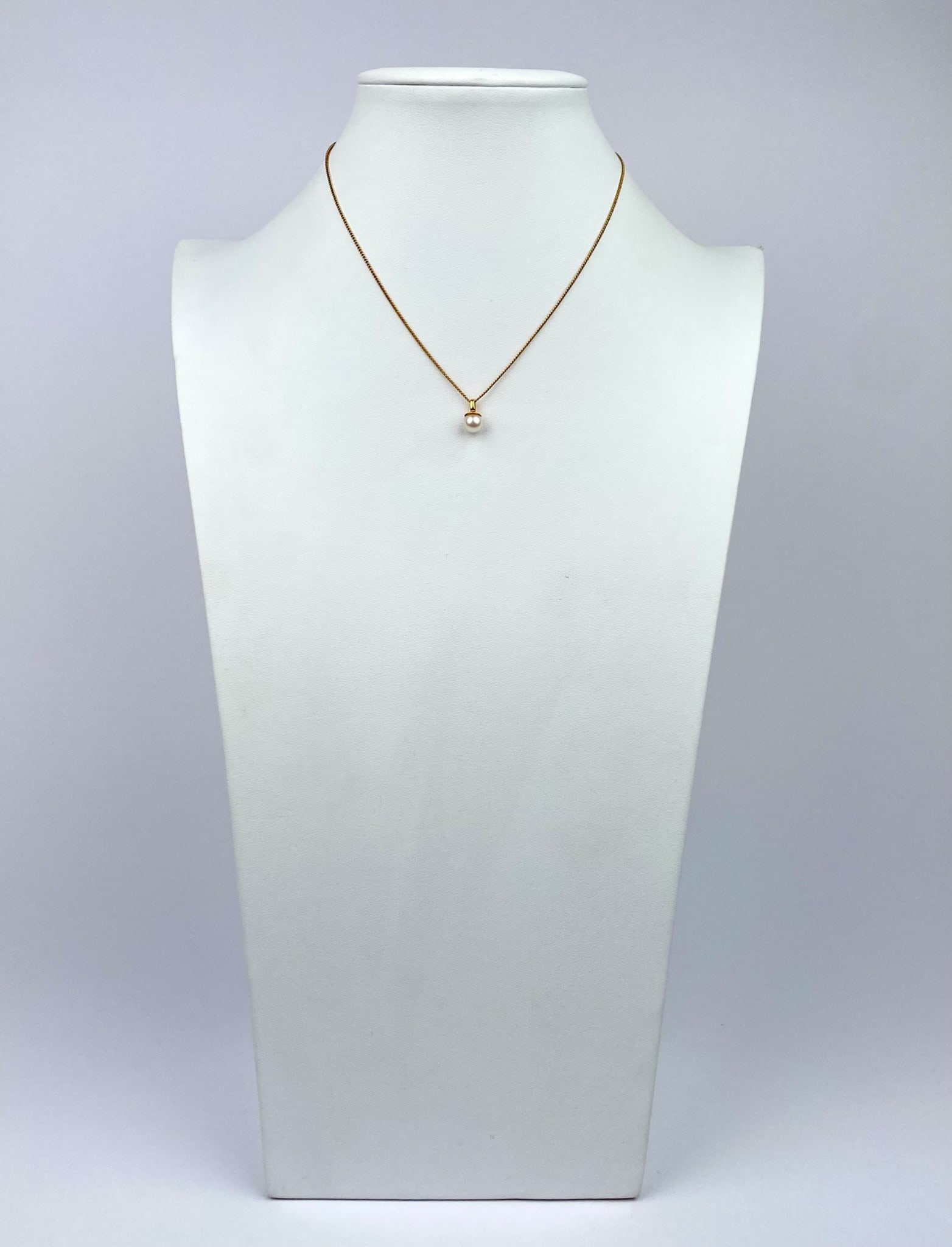 Gold Filled Chain Necklace with Pearl Pendant: Gold filled chain necklace featuring a single pearl pendant. The necklace is crafted with a fine chain and includes a spring-ring clasp closure for secure wear. The pearl is mounted on a gold bail, co