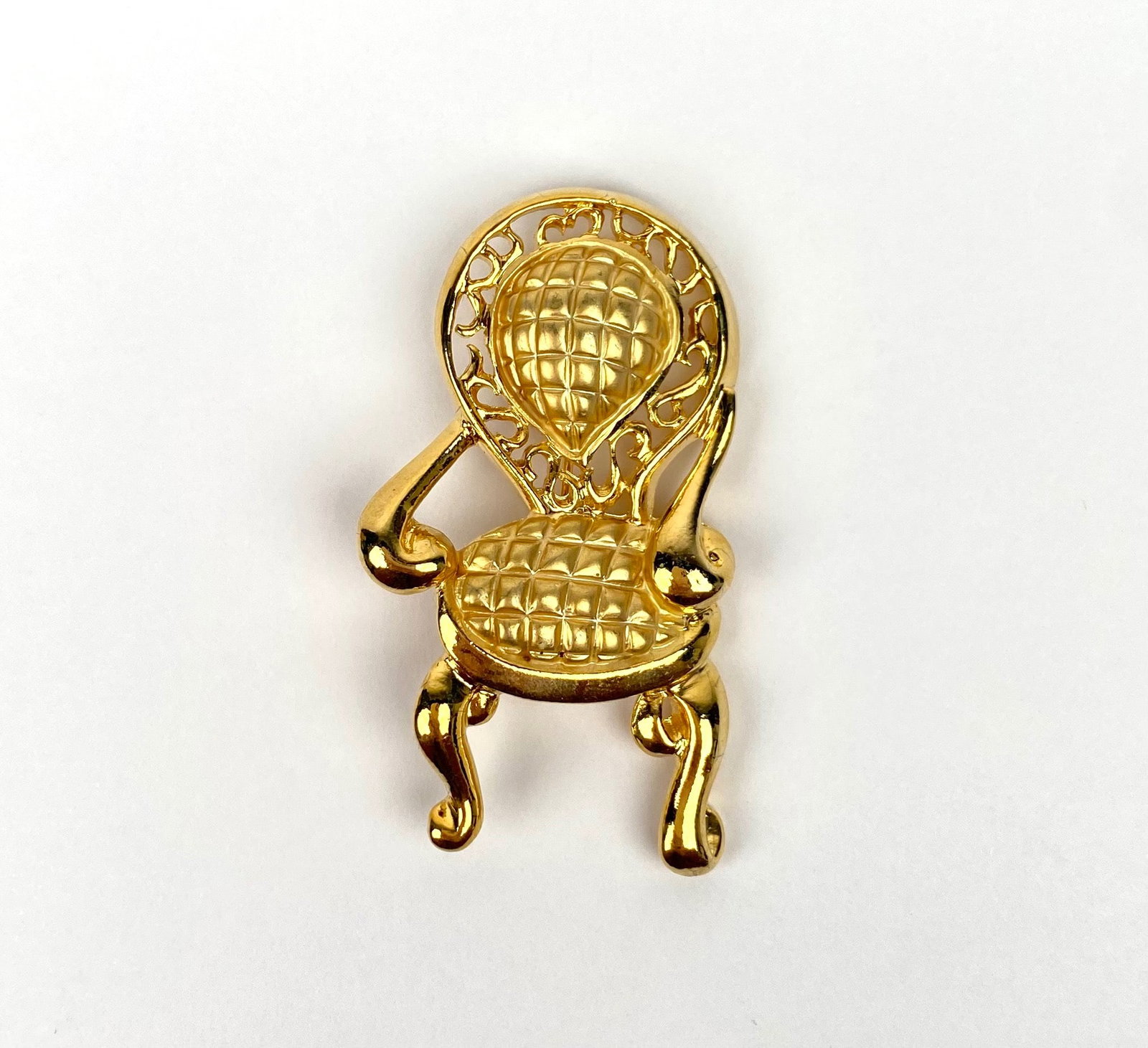 Signed Don-Lin Gold-Tone Chair Brooch: Gold-tone metal brooch in the shape of an ornate chair, featuring intricate detailing on the backrest and seat. The brooch is signed “DON-LIN” on the back. The pin mechanism is intact. | Pleas