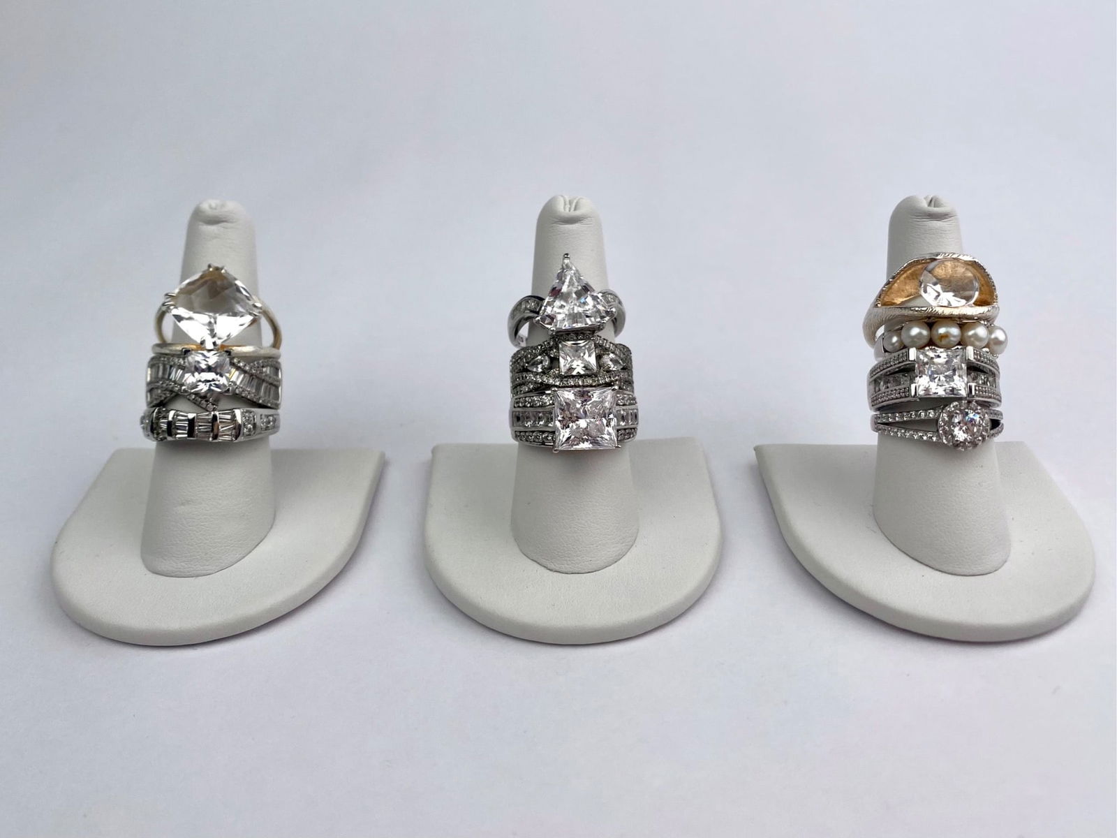 Group includes ten sterling silver rings featuring a variety of designs. Styles include solitaire: Group includes ten sterling silver rings featuring a variety of designs. Styles include solitaire and multi-stone settings with square, round, and trillion-cut clear stones, channel-set and pave accen