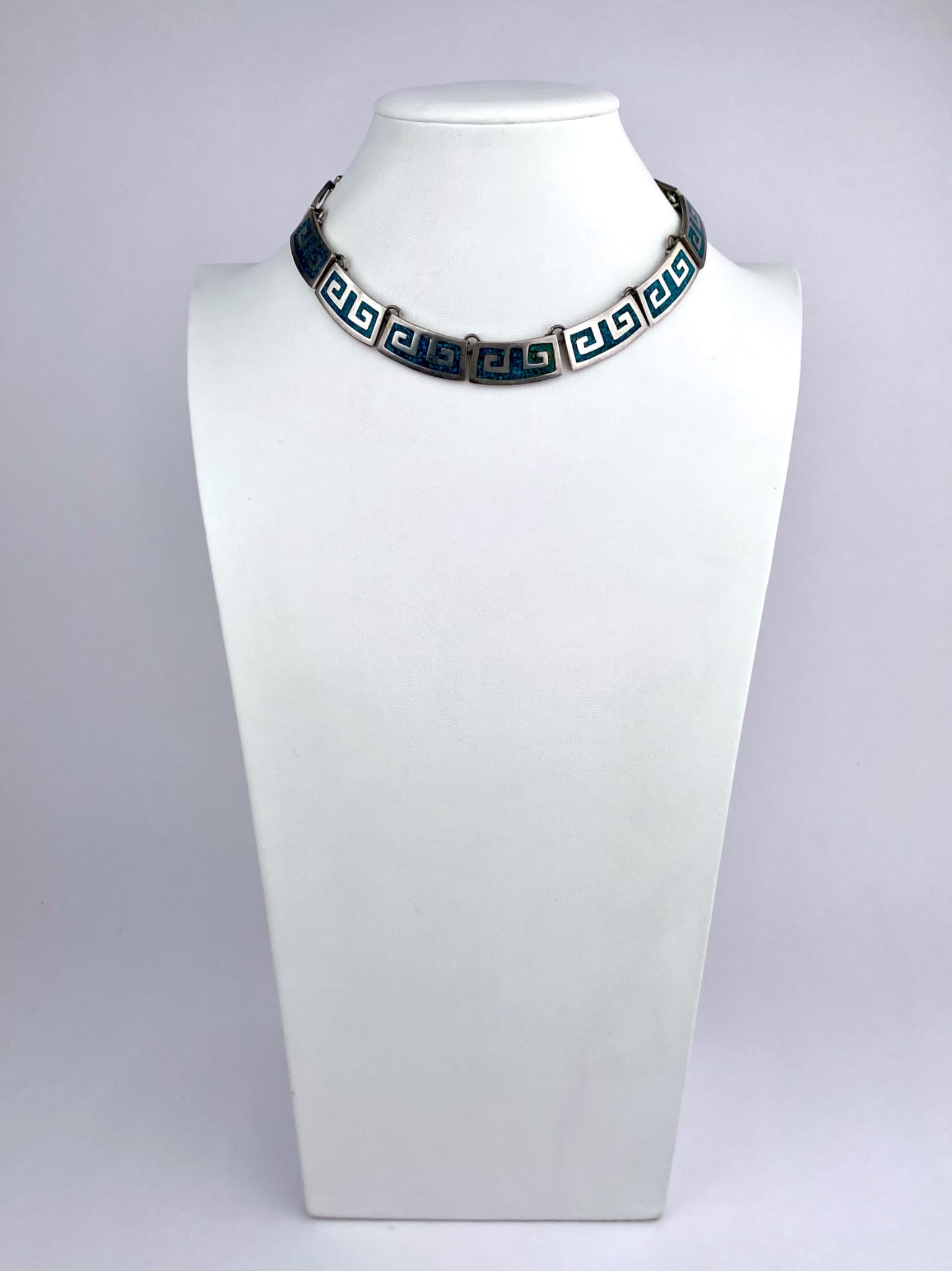 Mexican Sterling Silver Greek Key Inlay Necklace: Sterling silver necklace composed of rectangular panel links, each featuring a Greek key motif with turquoise-colored mosaic inlay. The reverse is stamped "Mexico 925." Finished with a box clasp. Neck