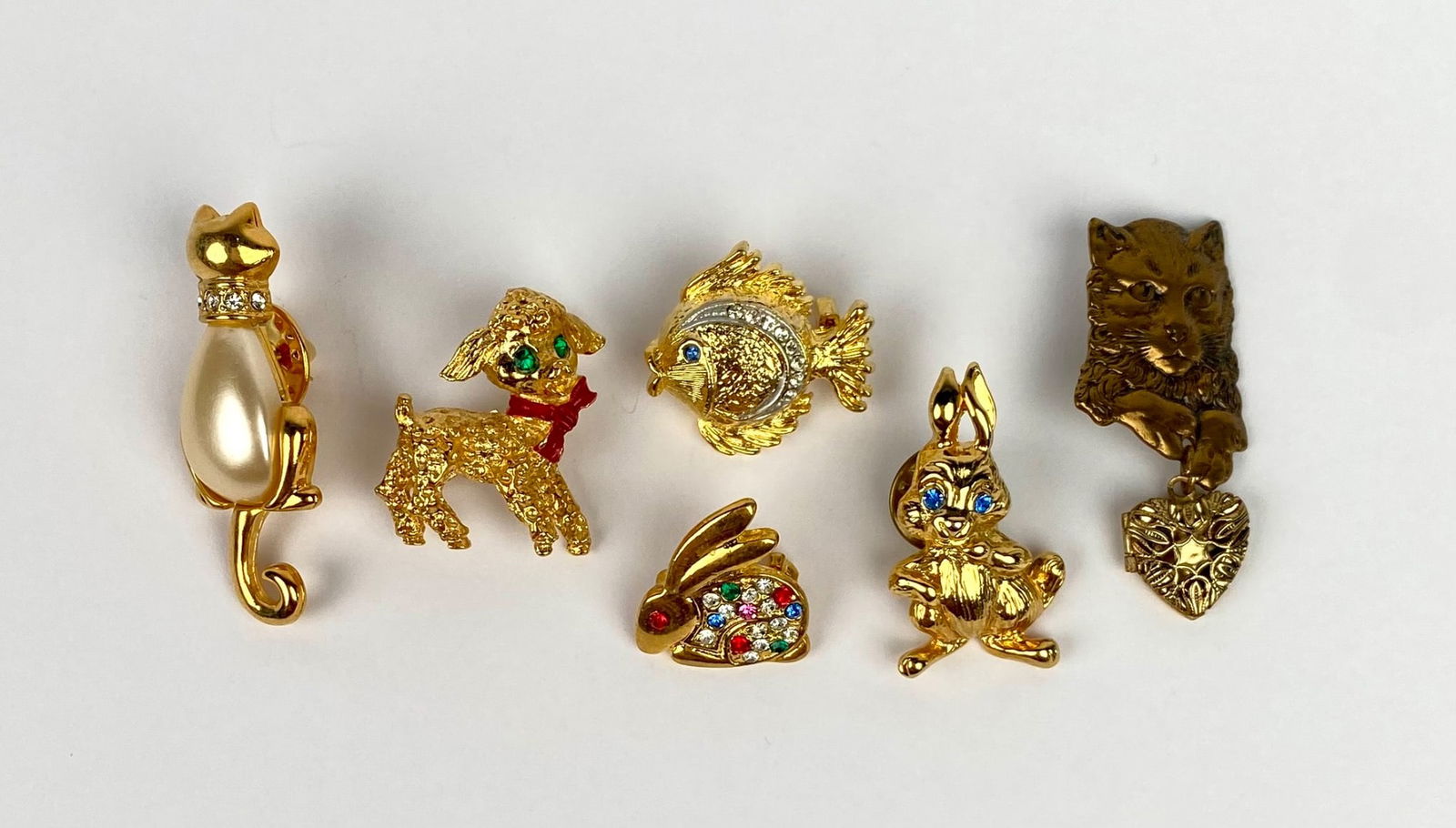 Lot of 6 Vintage Gold-Tone Animal Brooches: Six vintage gold-tone brooches, including a cat with a faux pearl body, a red-scarf dog, a rhinestone-adorned fish, two rabbits (one with multicolored rhinestones), and a cat with a heart locket. Each