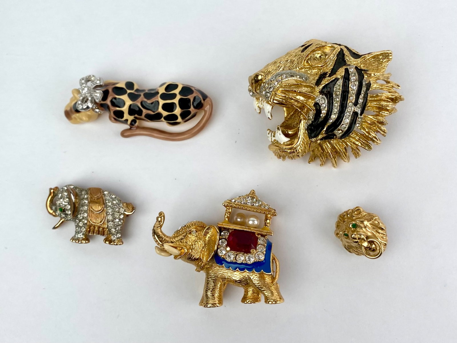 Group of Five Vintage Gold-Tone Figural Animal Brooches: Lot includes five vintage gold-tone figural animal brooches. The group features a roaring tiger head brooch with black enamel striping and clear rhinestone accents, an enamel spotted leopard brooch wi