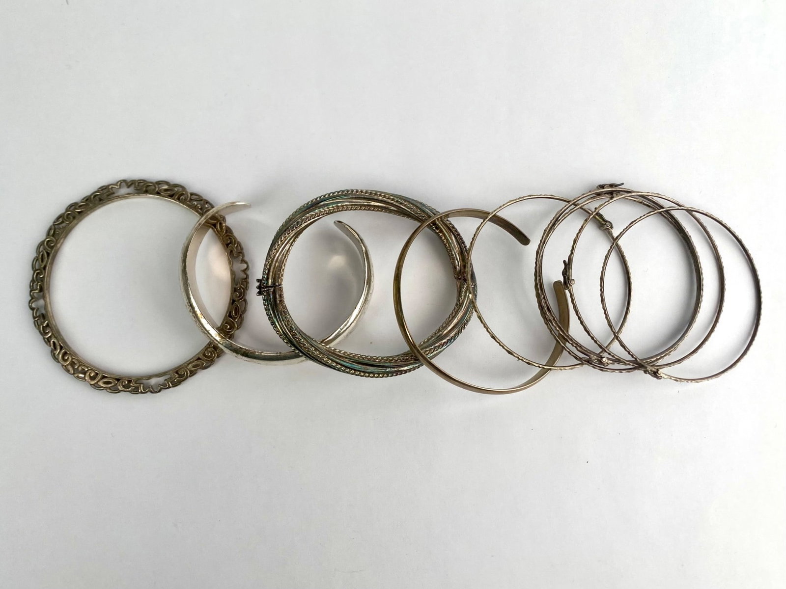 Group of bracelets and brangles in mixed sterling silver and silver-tone metal. The lot includes an (1 of 11)