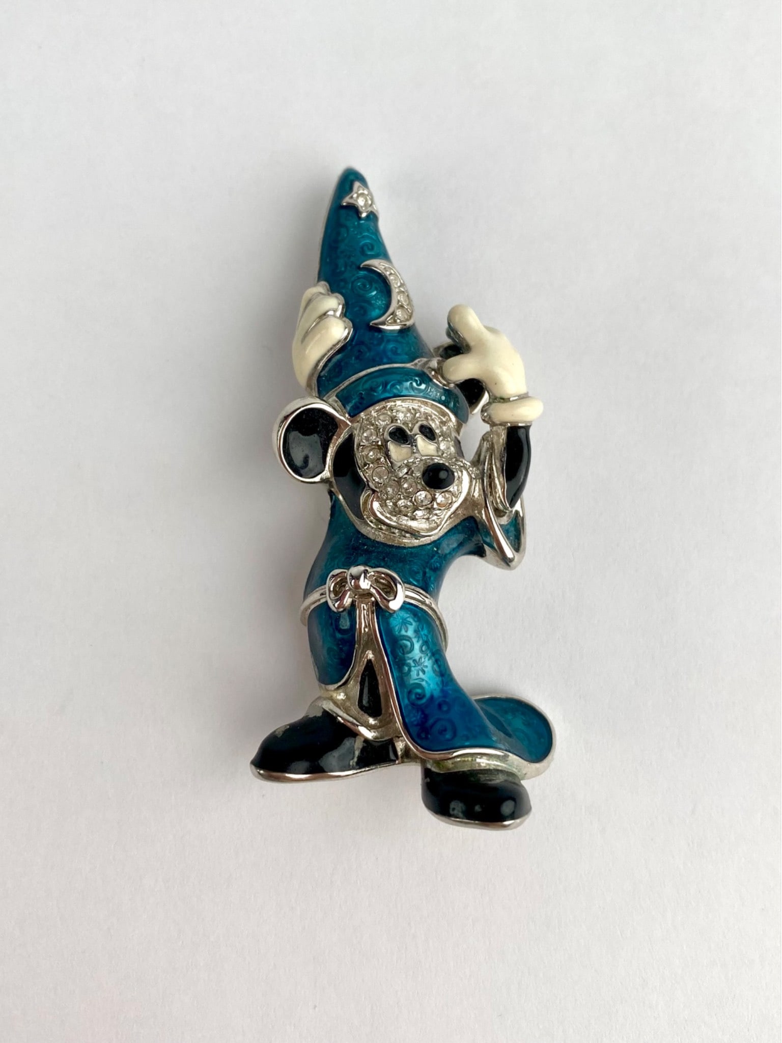 Disney Sorcerer Mickey Mouse figural brooch, depicting Mickey in his iconic Fantasia sorcerer: Disney Sorcerer Mickey Mouse figural brooch, depicting Mickey in his iconic Fantasia sorcerer attire. The brooch features blue enamel robes with engraved swirl detailing, black enamel accents, and cle