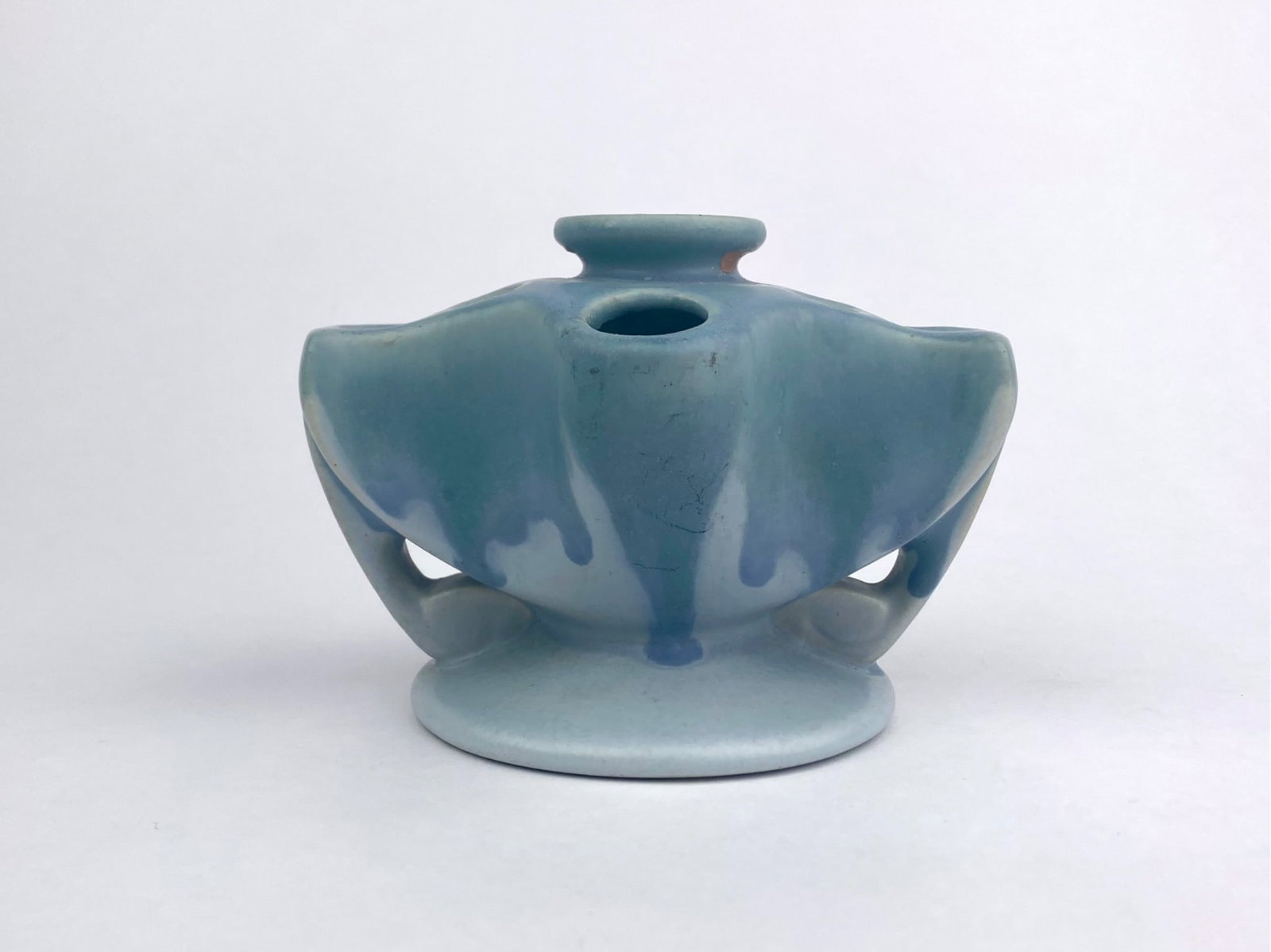 Roseville flower frog vase featuring a sculptural Art Decor form with multiple openings designed to: Roseville flower frog vase featuring a sculptural Art Decor form with multiple openings designed to hold flower stems. The piece has a matte blue glaze with darker blue drip accents and integrated
