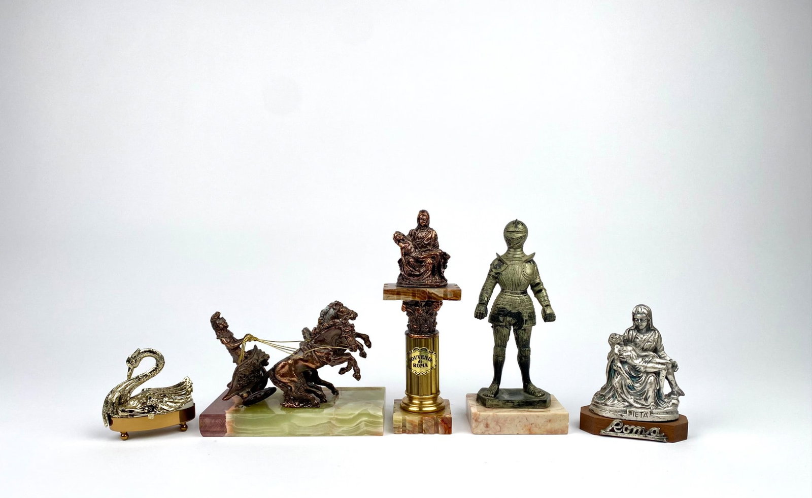 Lot of Five Italian & European Souvenir Figural Pieces: Five decorative figurines, including a gold-tone metal swan, a miniature Roman chariot scene mounted on a green onyx base, a bronze-like statue of Pieta on a marble column labeled ‘Souvenir