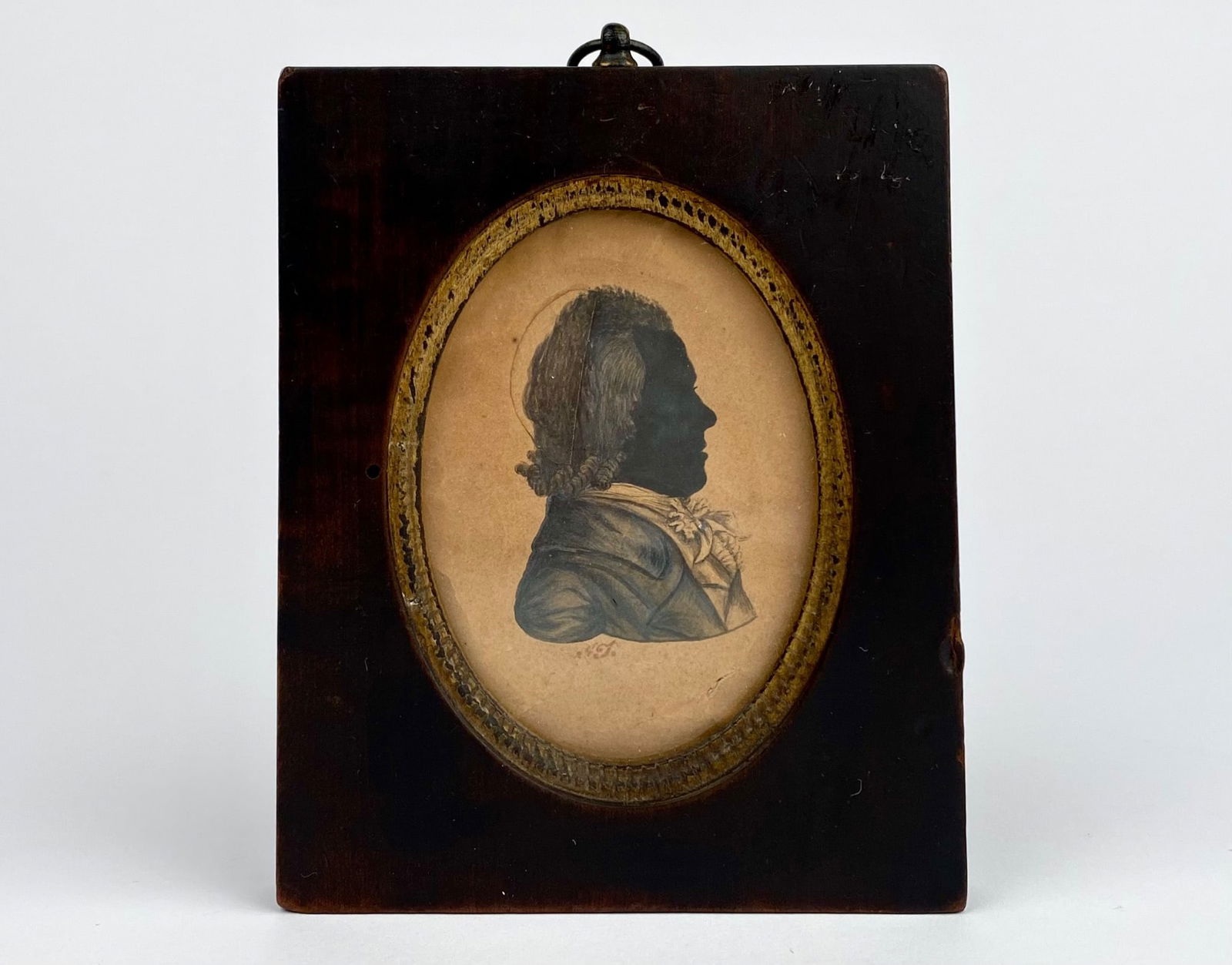 Early 19th century oval silhouette portrait on paper of a gentleman, housed in a wooden frame: Early 19th century oval silhouette portrait on paper of a gentleman, housed in a wooden frame featuring a gold oval accent. The reverse side shows a taped wooden backing. Early 19th century. Signs of