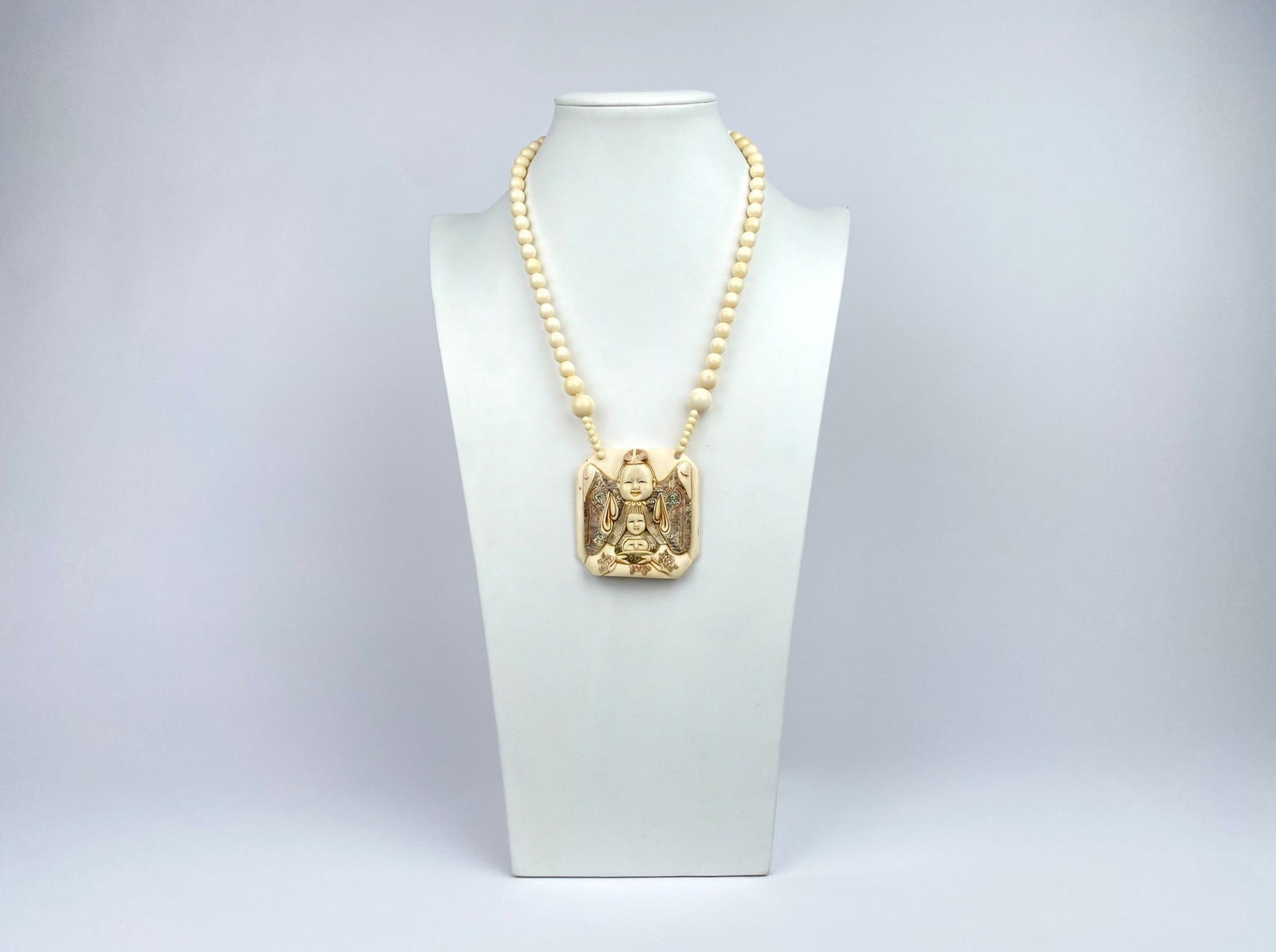 Carved beaded necklace featuring a central pendant intricately depicting Buddha surrounded by floral: Carved beaded necklace featuring a central pendant intricately depicting Buddha surrounded by floral and decorative accents. The back of the pendant showcases engraved characters and stamped