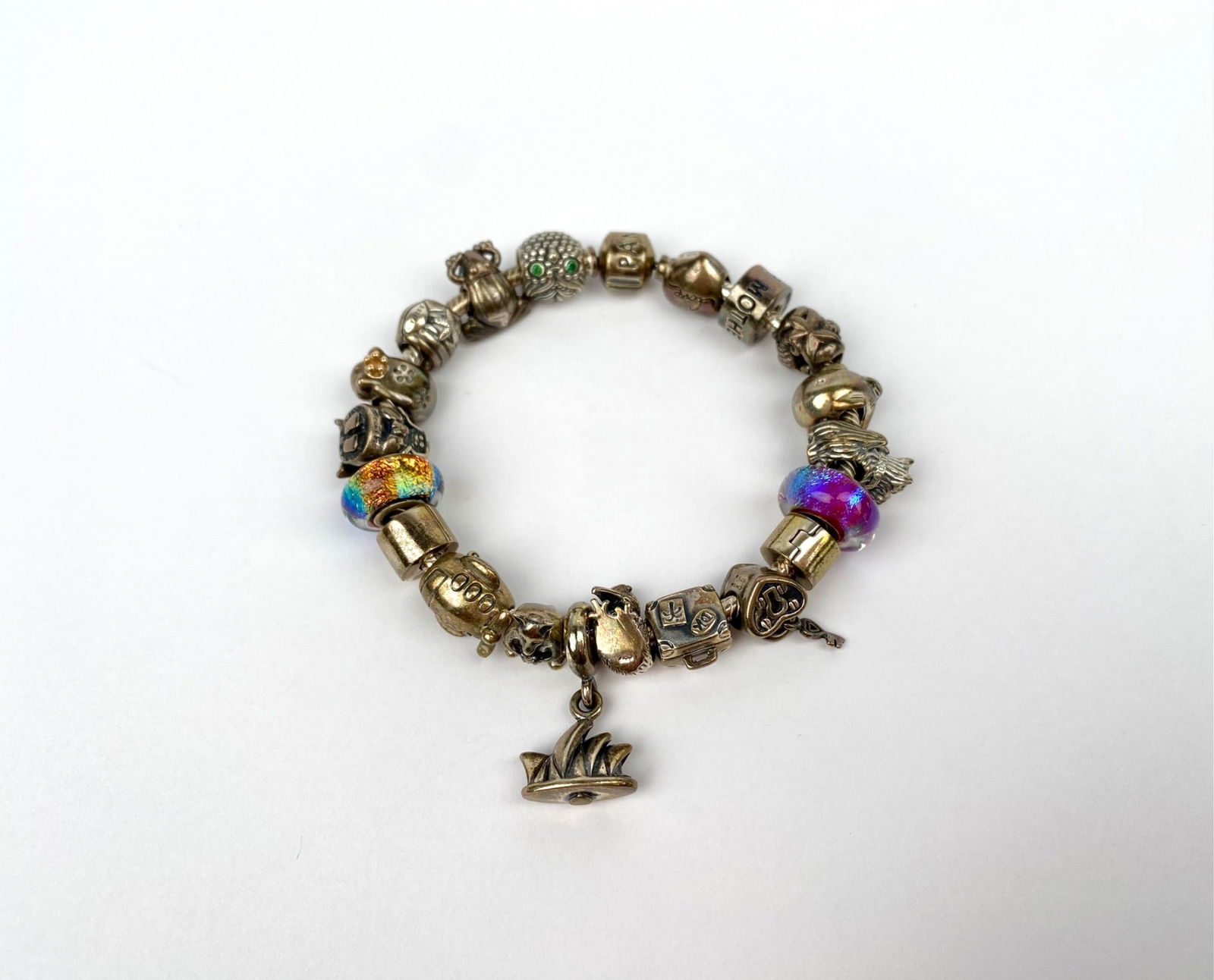 Sterling silver charm bracelet featuring multiple decorative beads and charms. The piece includes (1 of 8)