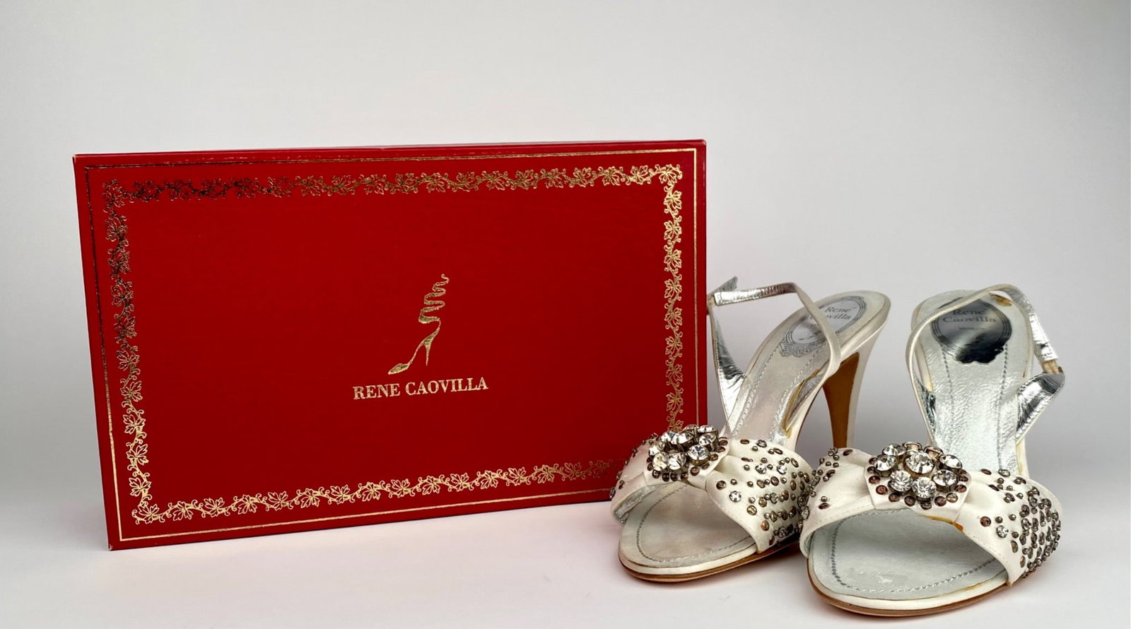 Rene Caovilla White Embellished Satin Slingback Heels with Box, Size 39: Rene Caovilla white satin slingback heels adorned with rhinestone and bead embellishments on the front. Features a silver metallic insole and a leather sole marked “Made in Italy”. Size 39. Or