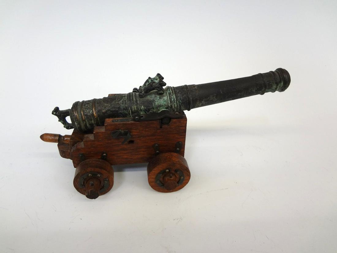 Bronze Swedish Metal Art Carlskona Ornamental Cannon on: Bronze Swedish Metal Art Carlskona Ornamental Cannon on Wooden Base: Copy of a 24 pound cannon from a Regal ship WASA. Made by Swedish Metal Art. Measures 8" long, and sits on wooden base.