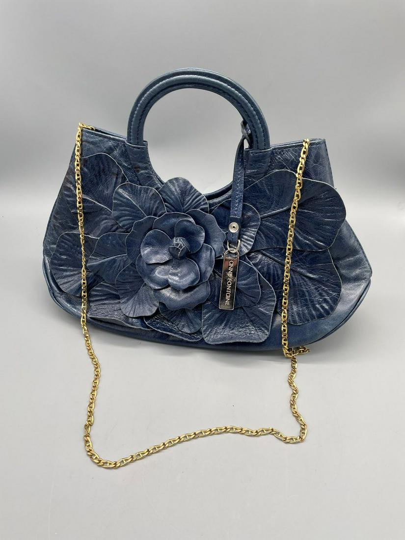 Anne Fontaine Designer Hand Bag: Anne Fontaine Designer Hand Bag: Blue leather, gold tone shoulder strap. Floral front design. In excellent condition. Measures 13" long, 10" high.