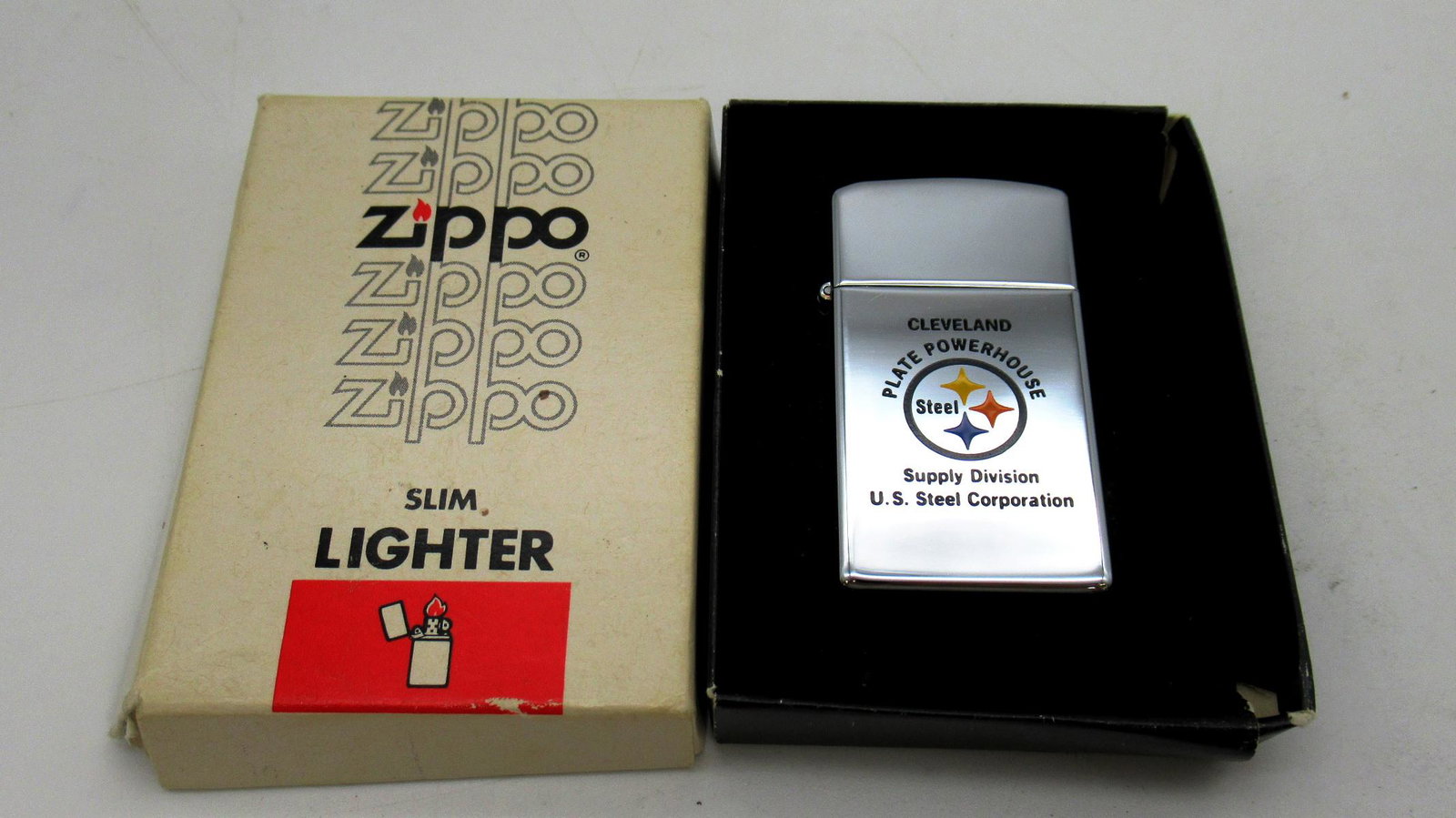 1981 Zippo Slim Lighter: 1981 Zippo Slim Lighter is engraved with Cleveland Plate Powerhouse Supply Division U.S. Steel Corporation. Includes original box that has some damage.