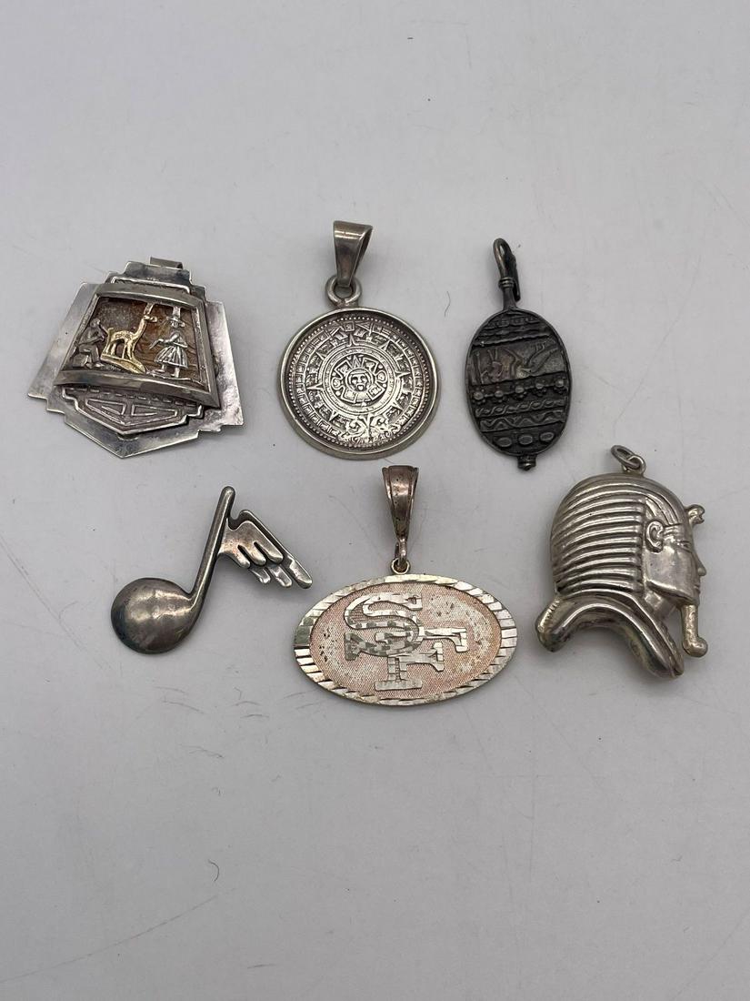 (6) Sterling Silver Pendants: (6) Sterling Silver Pendants: Total weight is 48.4 grams. Includes: aztec, 49er's, egyptian panel, pharoh, musical note, Mexican sandals.