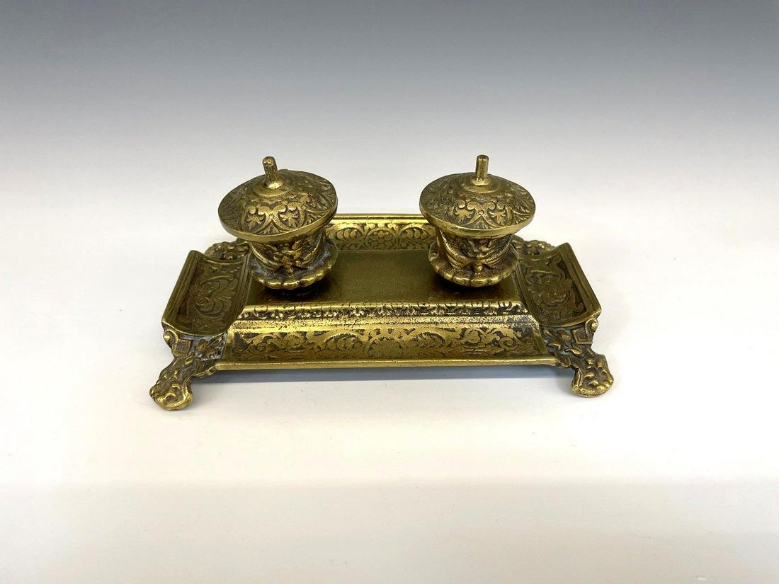 Brass Double Inkwell With Porcelain Bowls: Brass Double Inkwell With Porcelain Bowls: Marked on bottom. Measures 9.25" long and 4.25" tall. One porcelain bowl is chipped on edge.