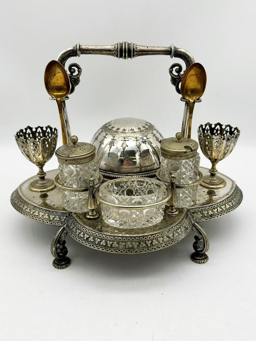 Victorian Quadruple Silver Plate Figural Breakfast Caddy: Victorian Quadruple Silver Plate Figural Breakfast Caddy: With 2 reticulated egg cups, condiment, sugar, covered dome with glass dish, 2 spoons (married to piece). Highly decorative etched floral leaf