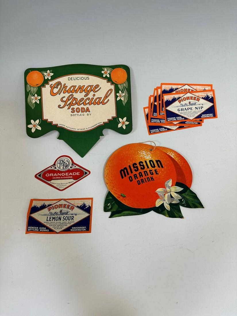 (5) Beverage Advertising Labels and Cardboard Signs: (5) Beverage Advertising Labels and Cardboard Signs: Mission Orange Crush double sided. Delicious Orange Special Soda Sign, Orangeade decal Pioneer Soda Works, (1) Pioneer Lemon Sour decal, (11) Pione