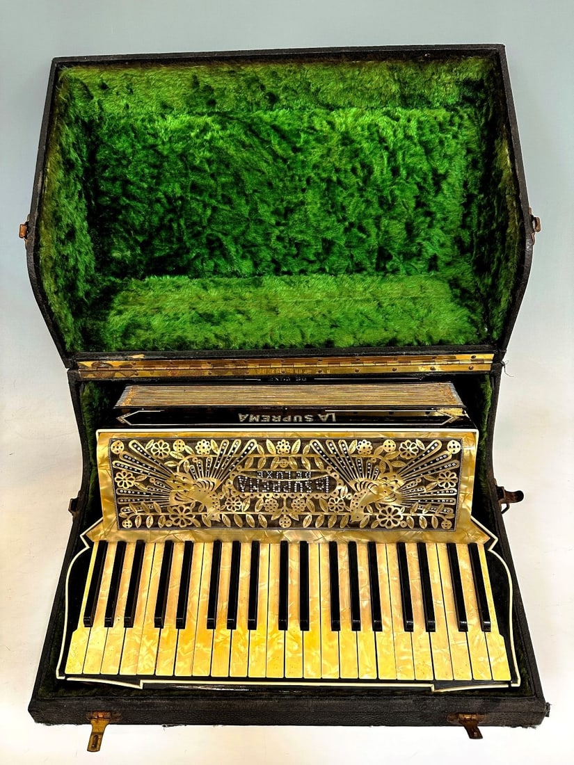 La Suprema Deluxe Piano Acordion: La Suprema Deluxe Piano Acordion made in Italy. Acordion has pearl celluloid two dove motiff, original case and straps. Third party shipping is required for this item.