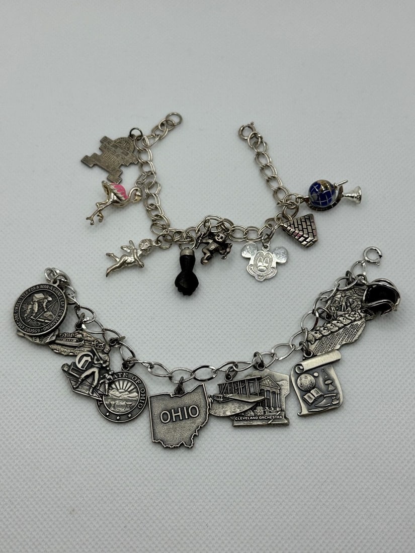 (2) Sterling Silver Charm Bracelets: (2) Sterling Silver Charm Bracelets: Includes on one globe, Mickey Mouse, angel, enamel flamingo. 8 in all 9" long. The other has Ohio charms, 12 in all 7" long. Total weight is 66.2 grams.