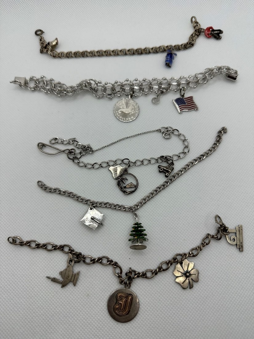 (5) Sterling Silver Charm Bracelets: (5) Sterling Silver Charm Bracelets: Total weight is 60.1 grams. 15 charms, 6.5"-7".