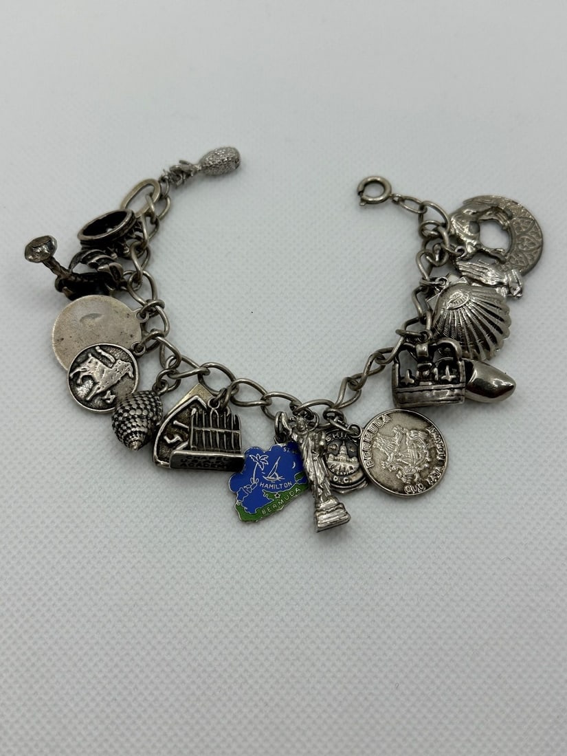 Sterling Silver Charm Bracelet With 17 Charms: Sterling Silver Charm Bracelet With 17 Charms: Includes Statue of Liberty, Egypt, Shell, D.C., shield, Bermuda and others. 63.5 grams.