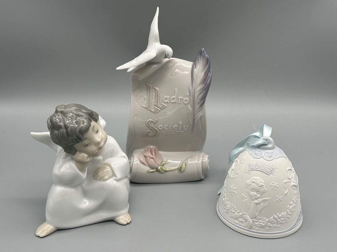 (3) Lladro Porcelain Figurines: (3) Lladro Porcelain Figurines: Includes Society Plaque, 2000 Bell, Thinking Angel. Plaque measures 7.75".