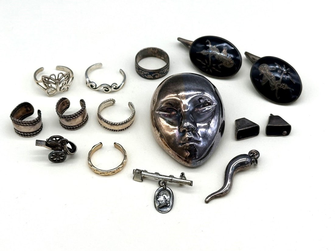 Group of Miscellaneous Sterling Silver Jewelry: Group of Miscellaneous Sterling Silver Jewelry: Face brooch, horn pendant, 3 charms, 2 ear bands, 5 toe rings, and others.