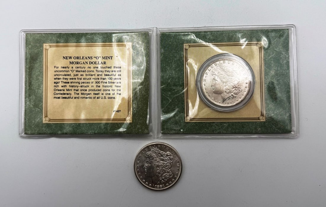 Group of (2) Morgan Silver Dollars: Group of (2) Morgan Silver Dollars includes the New Orleans "O" Mint Morgan Dollar 1885-O from the American Historical Socitey with COA and a 1881-S.