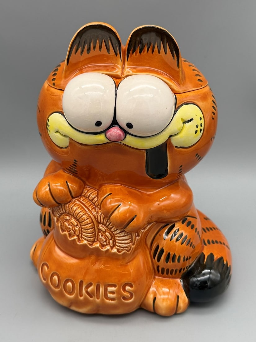 Garfield Enesco Cookie Jar: Garfield Enesco Cookie Jar: Measuring 8.75" tall, lid has light chipping underside.