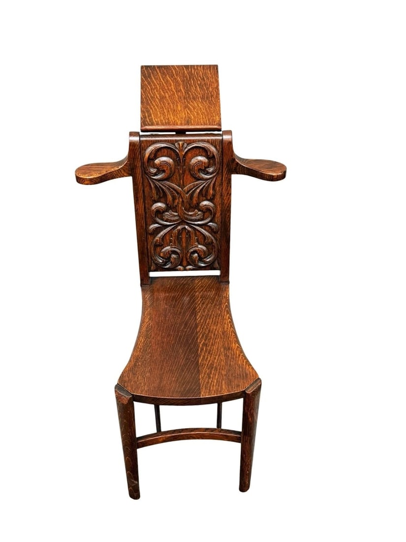 Unique Arts and Crafts Chair, Ornate Carvings: Unique Arts and Crafts Chair, Ornate Carvings. This solid oak chair is flared arm rest and a fold down hinged book rest. It is very unusual in its design and function. The chair measures 33.5" high, 1