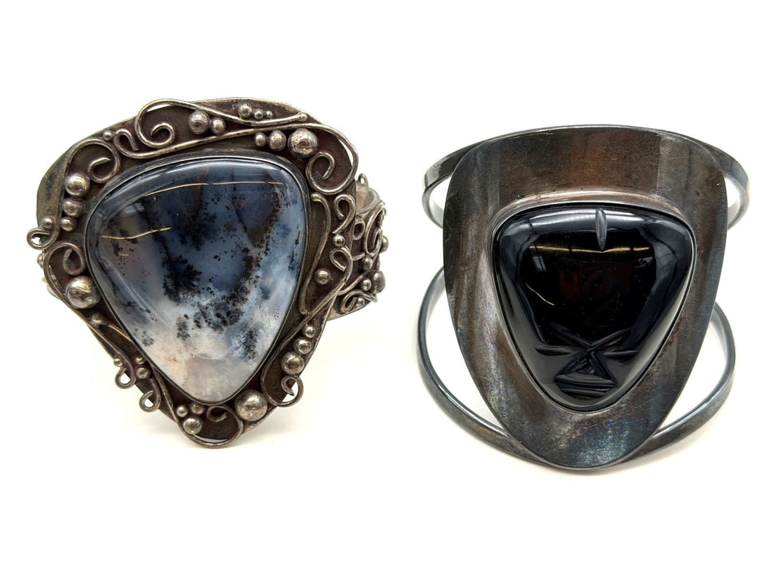 (2) Large Chunky Sterling Silver Cuff Bracelets: (2) Large Chunky Sterling Silver Cuff Bracelets: Agate center stone, black onyx head carved stone. Total weight is 134.7 grams.