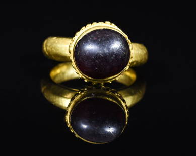 RARE LATE ROMAN GOLD RING WITH STONE: CA. 500-700 AD. Wearable ring with round hoop and integral ribbed bezel; large purple cabochon inserted. 17mm (inner diameter) 8 grams. Provenance: From an old British collection of Ancient jewelry, f