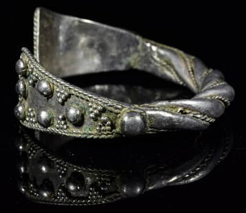 LARGE VIKING SILVER TWISTED BRACELET: Ca.900- 1100 AD. Wearable Viking Silver bracelet consisting of a thick silver twisted band and triangular shaped terminals with granulation. Fine Condition; W:73mm; 2.87 in; 38.5gr; Provenance: