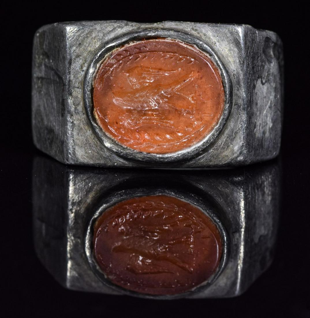 ROMAN LEGIONARY SILVER RING WITH EAGLE: Ca.200 AD. Amazing Legionary Roman silver intaglio ring with Laurel Wreath compromised by a roman legionary eagle in the central part of the intaglio. Fine Condition; Inner diameter: 20.5mm; outer dia