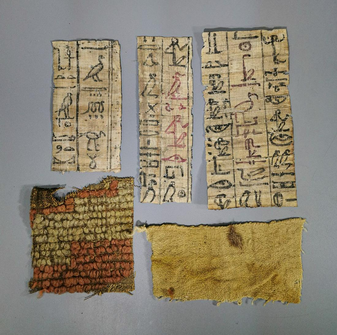 COLLECTION OF EGYPTIAN PAPYRUS AND FABRIC: Ca.100 BC-300 AD. Interesting collection of Egyptian papyrus and clothing fragments; 3 individual panels depicting multiple hieroglifs; Eye of Horus; Ibis; Snake; Falcon; the fabric is in pretty condi